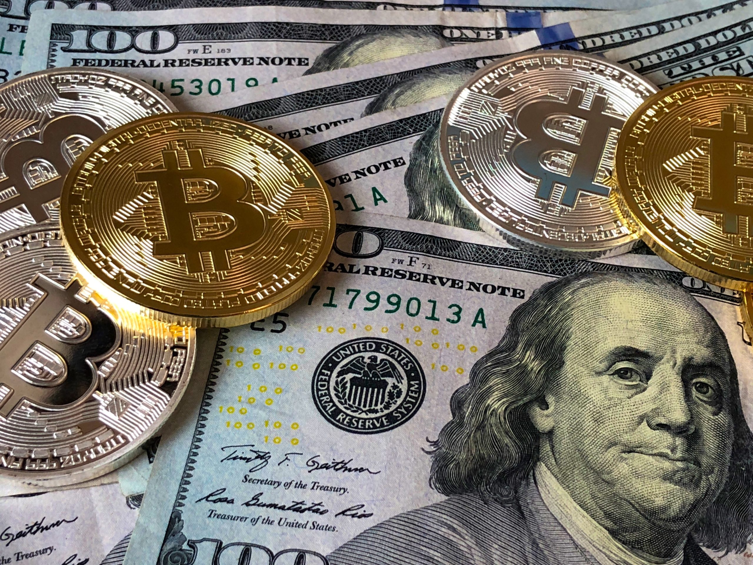 bitcoins on top of dollar bills